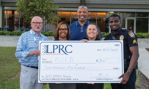 Group of people standing with giant LPRC donation check for the B.O.L.D. program