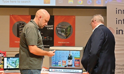 Two men talking at product booth at LPRC IMPACT event